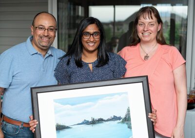 resident-grad-party three people are standing with a picture of sceneri